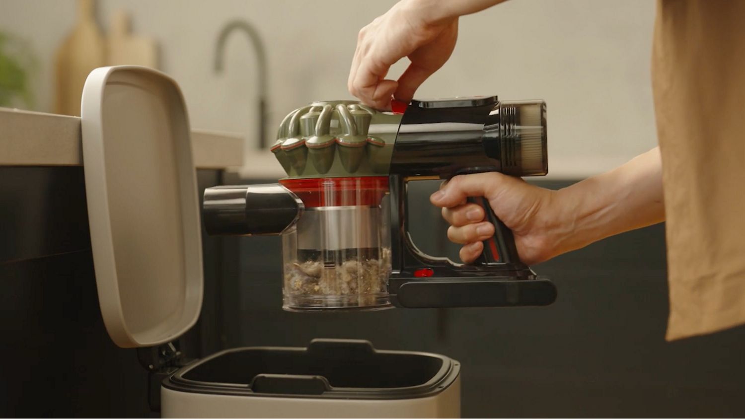 The Dyson V8 Cyclone vacuum is being emptied into a bin.